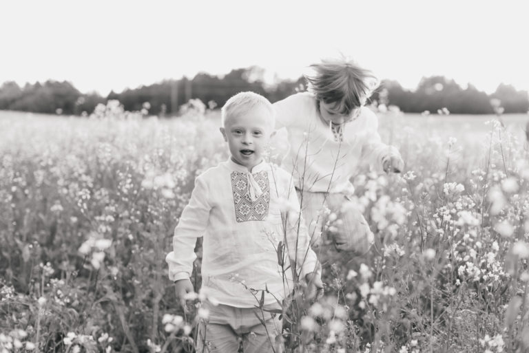 Barn med downs syndrom i blomstereng Barn med downs syndrom i blomstereng